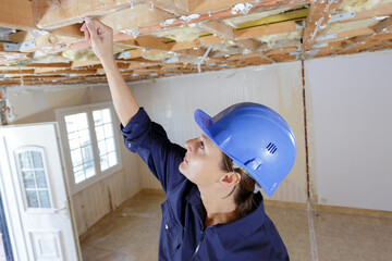Fototapeta premium female builder inspecting ceiling truss
