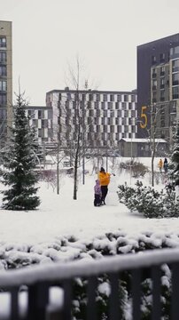 Father and child building snowman in winter park