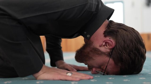 Muslim man in sujud prostration during prayer at a mosque. Young Muslim scholar performing Sajda in spiritual devotion. Ramadan spiritual moments at masjid. 
