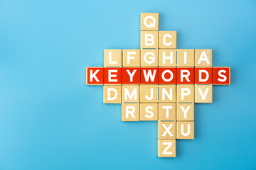 Keywords Concept with Wooden Alphabet Blocks on Blue Background