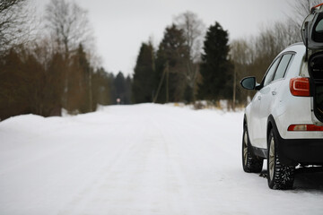 Winter Road Trip: Car Parked on Snowy Forest Road in Winter Landscape