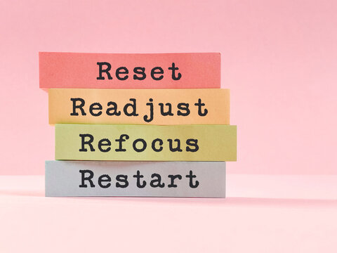 Motivational words reset, readjust, refocus and restart text on stack of paper notes representing self improvement, mindset change, fresh start and mental reset.