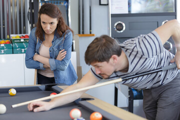 Obraz premium couple man and woman in a billiard hall playing pool