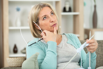 mature beautiful woman knitting at home