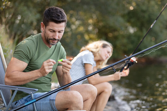 portrait of young couple fishing at lakeside