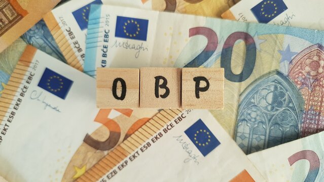 OBP acronym made of wooden letter cubes on pile of Euro banknotes. Ouderdoms- en Bedrijfspensioen (Old Age and Occupational Pension)