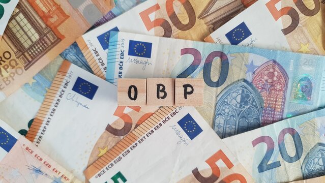 OBP acronym made of wooden letter cubes on pile of Euro banknotes. Ouderdoms- en Bedrijfspensioen (Old Age and Occupational Pension)