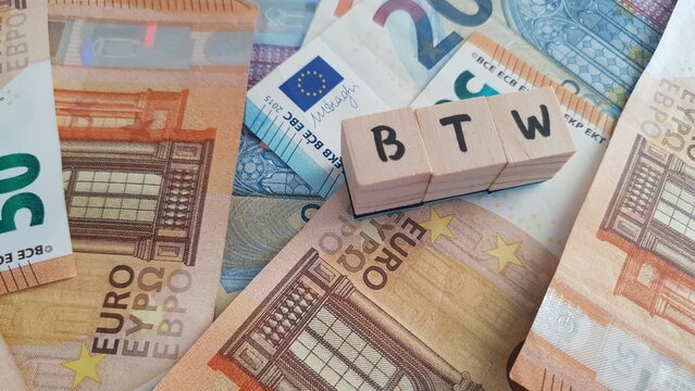 BTW acronym made of wooden letter cubes on pile of Euro banknotes. Belasting Toegevoegde Waarde (Value Added Tax)