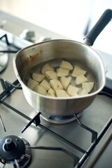 カットしたじゃがいもを鍋で茹でているところ