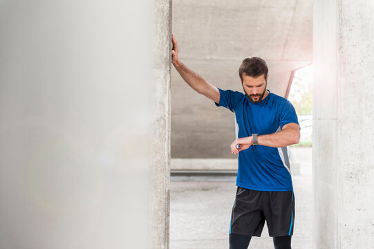 Man having a break from running checking the time