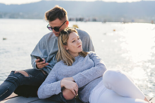 Young couple relaxing on jetty at Lake Zurich, Zurich, Switzerland