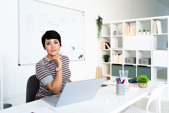 Portrait of businesswoman working at office in front of laptop