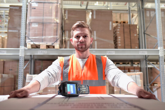 Portrait of confident man in factory hall with barcode scanner