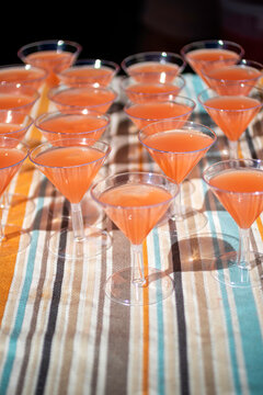 Plastic martini glasses with drinks on striped tablecloth
