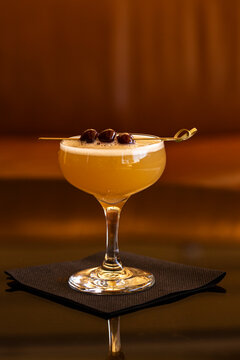 Stemmed glass with cocktail and garnished cherries on toothpick