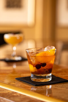 Mixed drinks on different shapes sit on a bar top
