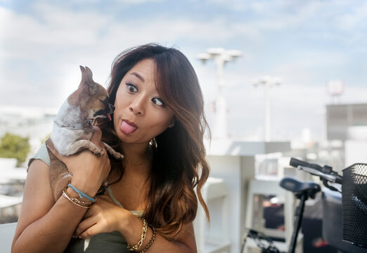 Portrait of woman at pavement cafe imitating her Chihuahua puppy