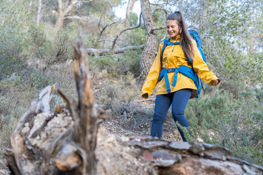 Woman hiking in nature wearing backpack and jacket