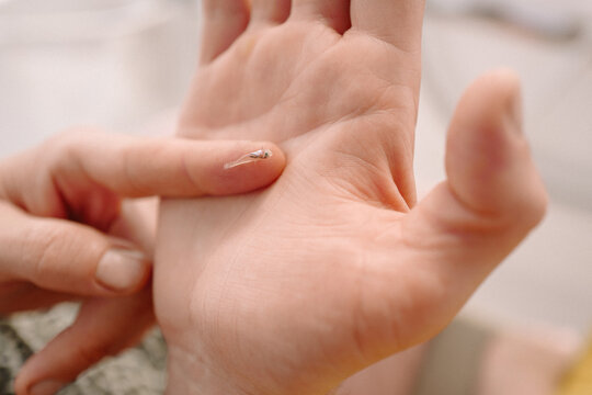 Macro close-up of a human hand holding a tiny transparent fish l