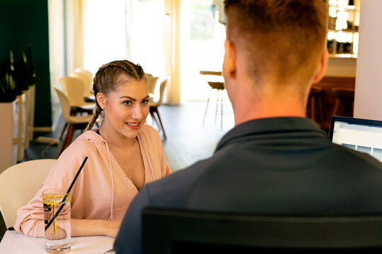 Smiling young woman looking at employee at desk in a gym