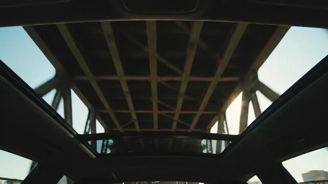 Interior view of bridge structure from sunroof with the sun shining, beams and metal