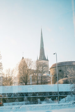 Tallinn Old Town in winter seen from a tram, snowy medieval skyline and church spires, atmospheric European travel journey concept