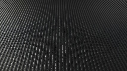 Abstract close up of black textured surface with droplets