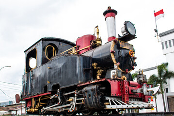 Old Vintage Steam Locomotive Monument with Black and Red Iron Body Exterior View of Antique Railway Train Engine for Transportation History and Retro Industrial Technology Concept