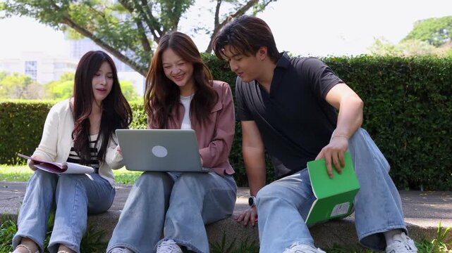 Three Asian College Students Studying Together Outdoors on University Campus