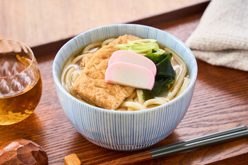 大きな油揚げにかまぼこを添えたきつねうどん