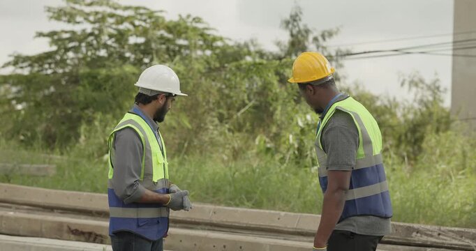 Railway engineer and technician conduct quality control material inspection on concrete pier segments and construction waste. Checking structural condition for safe site housekeeping and asset reuse.
