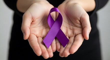 Hands holding a purple ribbon symbolizing cancer awareness and support