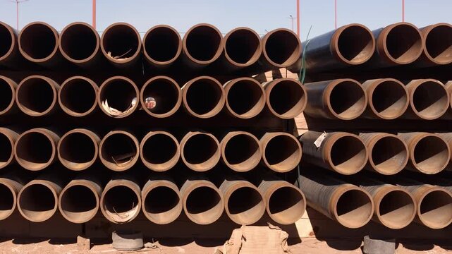 Stacked industrial pipes in sunlight, symbolizing construction and utility