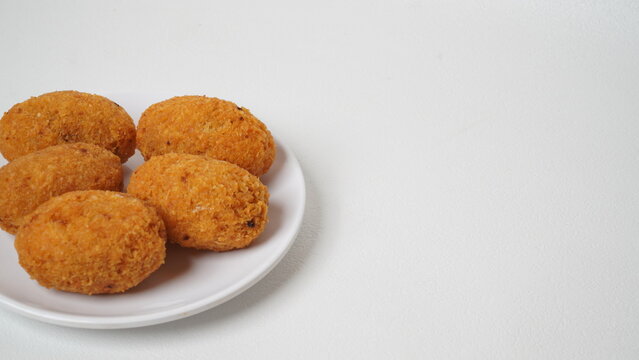 A snack called combro, typical of West Java, Indonesia, made from cassava with oncom chili sauce filling, served on a white plate and placed in a white place (isolated white).