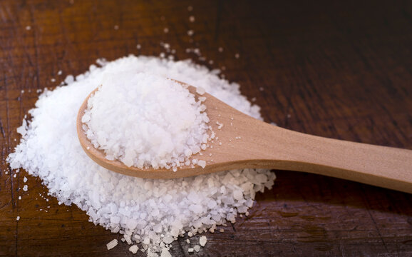 White coarse salt on wooden kitchen spoon