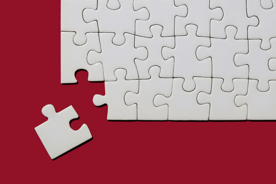 Studio shot of white puzzle pieces on red background