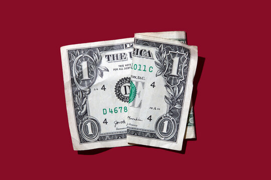 Studio shot of folded one dollar bill on red background