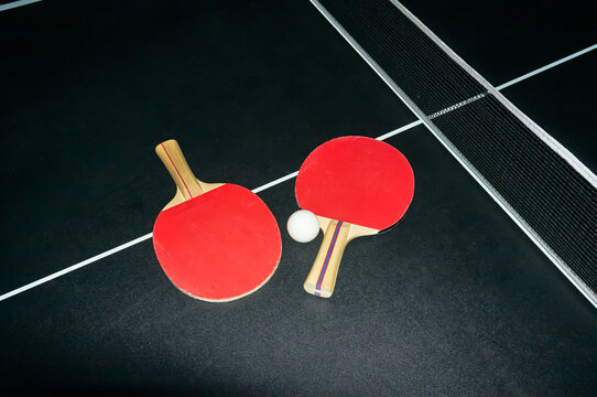Ping Pong ball and pair of red paddles
