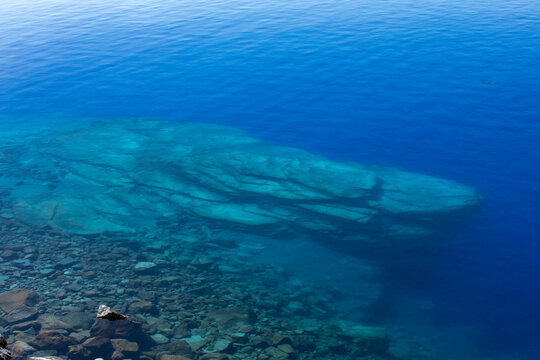 USA, Oregon, Rocks in blue calm Crater Lake