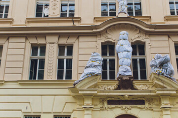 Weathered structure showcasing detailed sculptures and vintage architectural features. Old city street scene featuring elaborate stone carvings on historic baroque facade