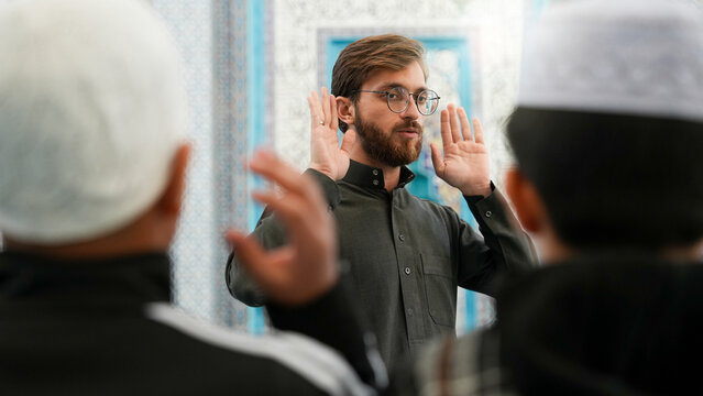 Muslim Sheikh teaching kids how to pray in a mosque. Ramadan Quran classes for children. Muslim kids learning Islamic prayer at masjid. Taraweeh prayer and Ramadan atmosphere.