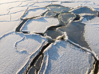 Aerial drone view of beautiful geometric ice floes and frozen patterns on the Baltic Sea surface in winter in Estonia.