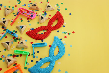 Purim celebration concept (jewish carnival holiday) over yellow background