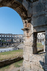 Obraz premium View through a stone arch of the amphitheater in Pula, Croatia