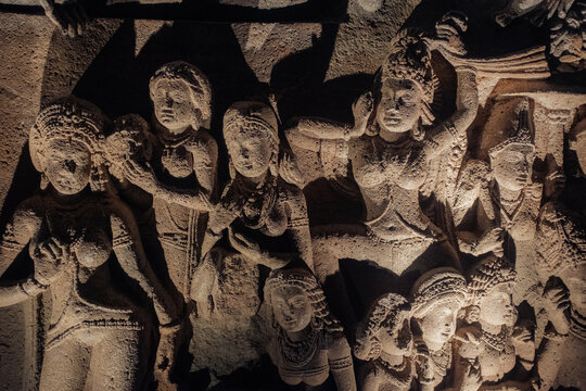 Ajanta, India - 26 December 2025: View of ancient carvings rendered in stark relief by shadows, revealing the intricate details of figures in a timeless dance.