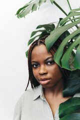 Portrait of a beautiful woman surrounded by lush green plants and foliage