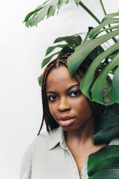 Portrait of a beautiful woman surrounded by lush green plants and foliage