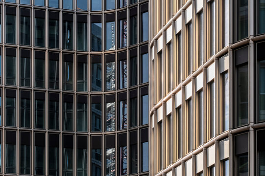 Curved glass window facade of modern urban corporate office architecture building creating sleek skyline perspective for business district design