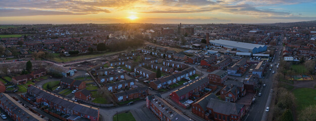 Aerial panorama looking north-west over Bolton, featuring traditional residential streets and industrial heritage against a dramatic Lancashire sunset. © bardhok