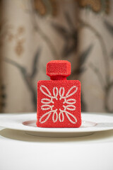 Elegant red mousse dessert with velvet texture served on white plate in restaurant setting